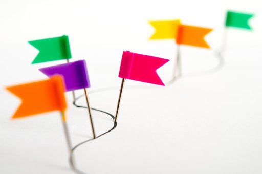Kleine bunte Fahnen auf weißem Untergrund. Die Fahnen sind durch eine sich schlängelnde Linie verbunden.