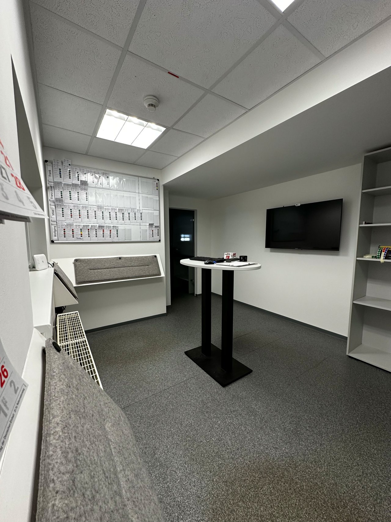 Das Bild zeigt einen Büroraum mi Stehtisch.