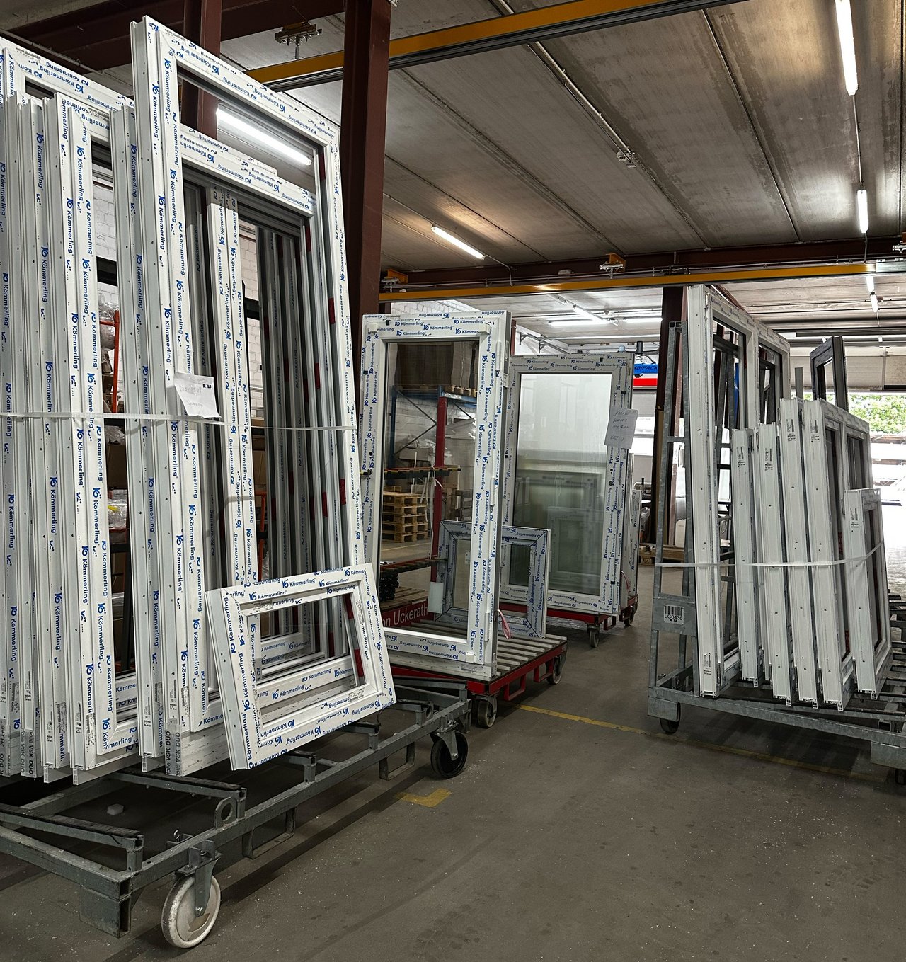 Das Bild zeigt fertig produzierte Fenster der ROLF Fensterbau GmbH, die in einer Halle gelagert werden.