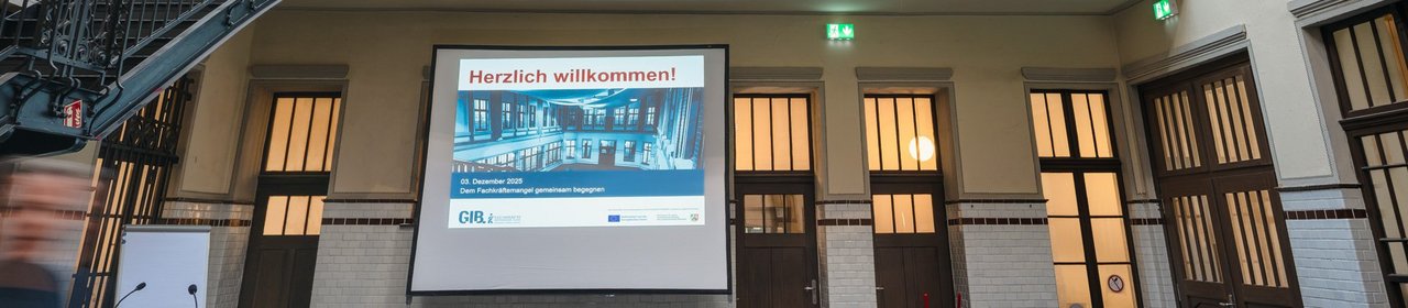 Das Foto zeigt die Lohnhalle in Bottrop und die Präsentation mit dem Titel "Herzlich willkommen".